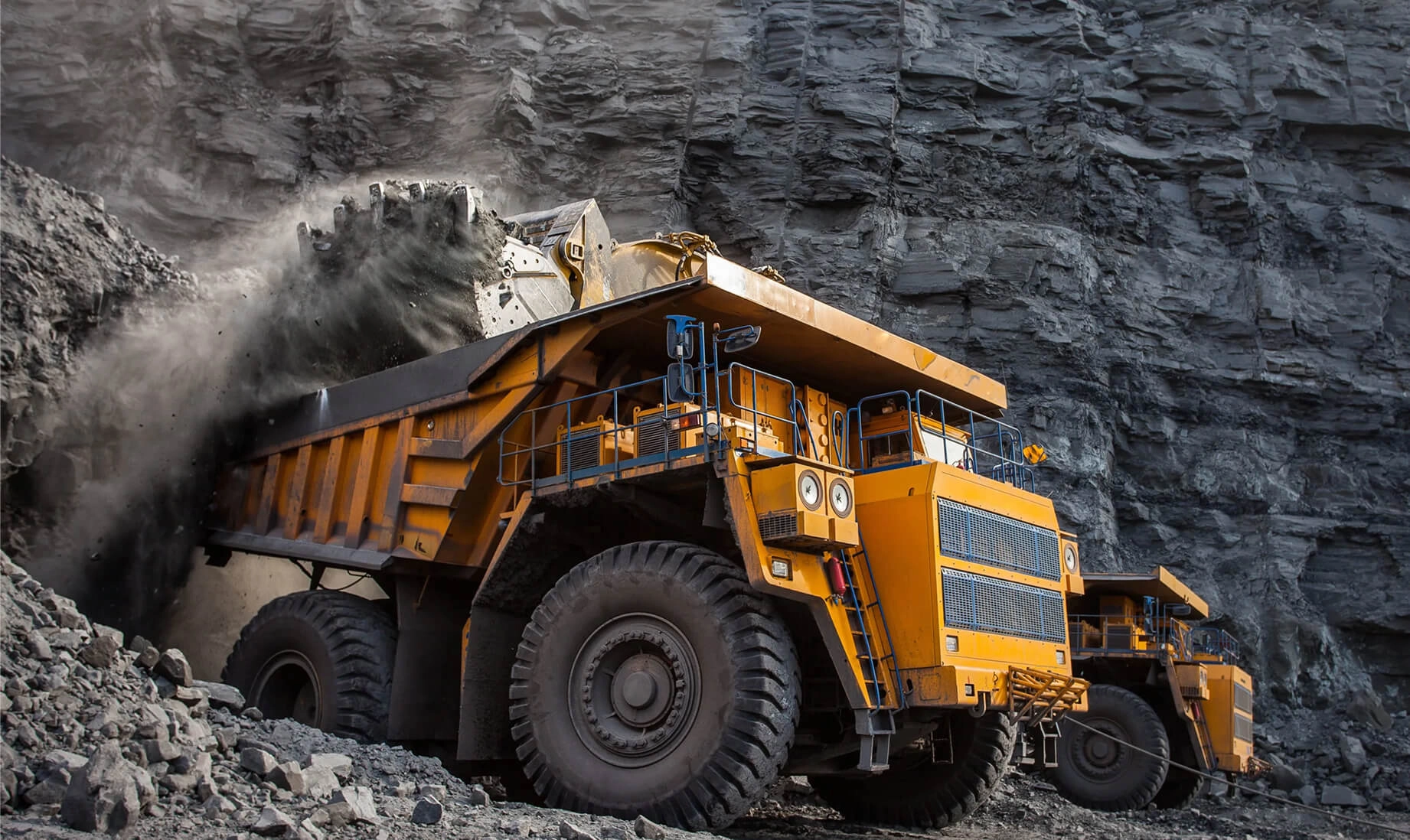 Mining trucks and excavator at work site
